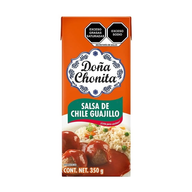 salsa de chile guajillo la costeña doña chonita 350 g envase frontal centrado; cartón naranja con logo blanco y azul "Doña Chonita", banda verde que indica "Salsa de Chile Guajillo", foto de albóndigas con salsa y arroz abajo, sellos negros "Exceso grasas saturadas" y "Exceso sodio" en la parte superior; también suele usarse para sazonar mixiotes y guisos familiares.