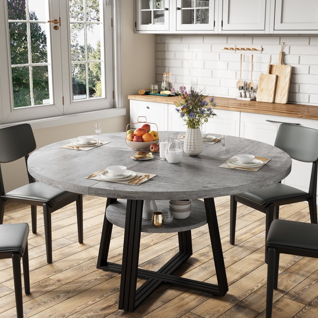 yeshouse mesa de comedor redonda de 120 cm para 4-6 personas, diseño rústico gris con tablero circular y base en cruz metálica; vista 3/4 centrada que muestra estante inferior redondo de 59 cm para almacenamiento, patas negras de metal y superficie lisa, ambientada en cocina-comedor con sillas; también suele usarse como mesa de reuniones o para tareas cotidianas en apartamentos.