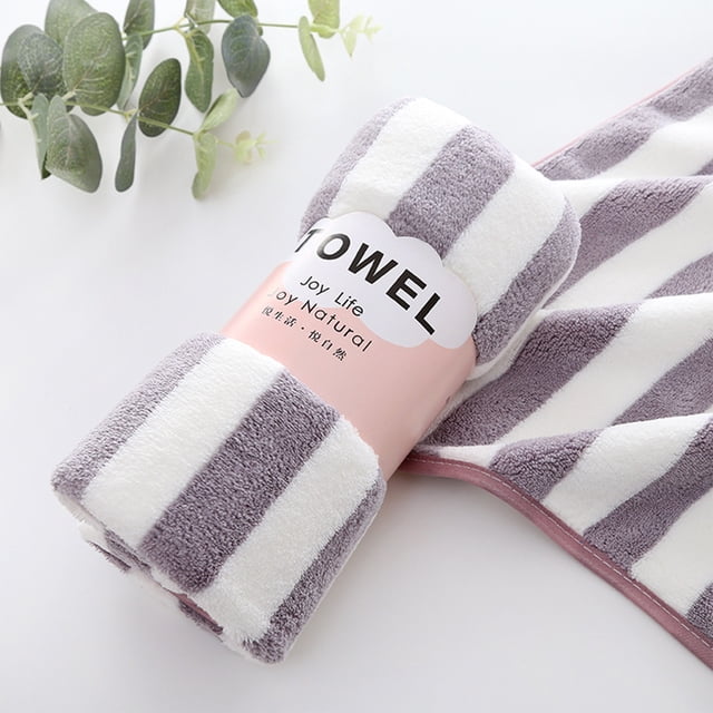 toallas de baño suaves, gruesas y absorbentes. ideales para el hogar, gimnasio, piscina, yoga, hotel y ducha. toalla grande para el baño. Toalla de baño grande morada y blanca de felpa 35×75 cm con diseño de franjas, vista 3/4 mostrando rollo y parte desplegada; borde doble cosido visible y textura de felpa; apta para casa, gimnasio o playa, y a menudo usada como toalla ligera para viaje.