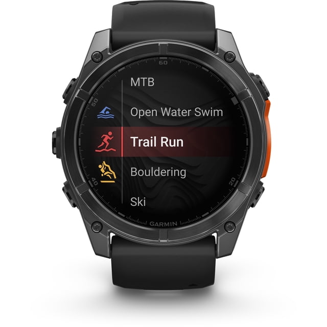 garmin, monitor deportivo, fenix 8, 51mm, amoled,glass, slate gray reloj multideporte 51 mm con pantalla AMOLED en vista frontal. Bisel y caja en gris pizarra, correa negra de silicón y botón naranja lateral derecho. Pantalla muestra modos de actividad como Trail Run y Open Water Swim.