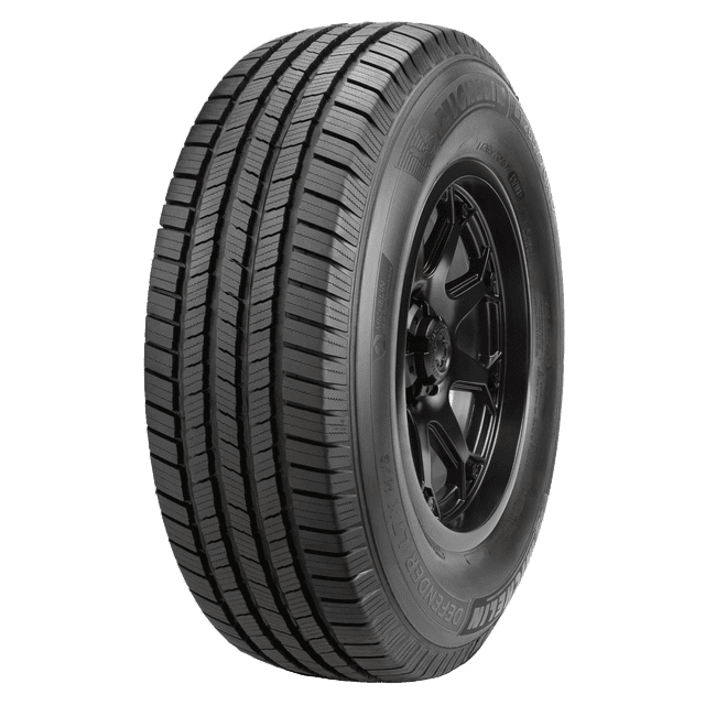 llanta 265/75r16 lt michelin defender ltx 123/120r vista 3/4 de una llanta Michelin Defender LTX 265/75R16 LT montada en rin 16 negro, banda de rodamiento con cuatro canales longitudinales y bloques de agarre visibles; costado con marcaje 'Defender LTX' y dibujo profundo, con distancias de frenado más cortas en piso mojado según especificación.