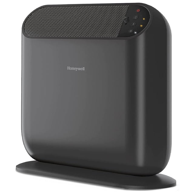 calentador portátil honeywell thermawave 6, cerámica, negro — Vista frontal en 3/4 de calentador cerámico negro con base ovalada; carcasa lisa con logotipo Honeywell centrado; rejilla superior para salida de aire y panel de controles digitales con botones y luces en la esquina superior derecha; compacto y apto para uso personal en habitación u oficina.