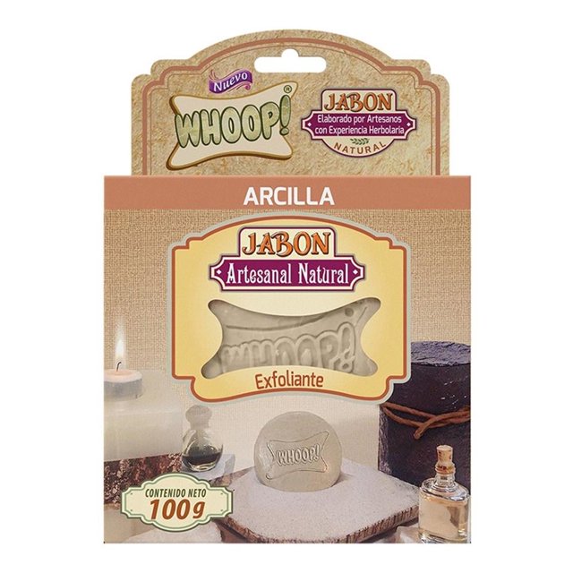 jabón artesanal whoop! arcilla 100g Barra de jabón artesanal Whoop! Arcilla 100 g en empaque frontal; barra beige con relieve 'WHOOP!' visible por ventana, etiqueta 'Jabón Artesanal Natural' y banda superior 'ARCILLA', fondo con toalla y frascos de tocador. Adecuado como jabón corporal para uso diario y a menudo usado para exfoliación suave.