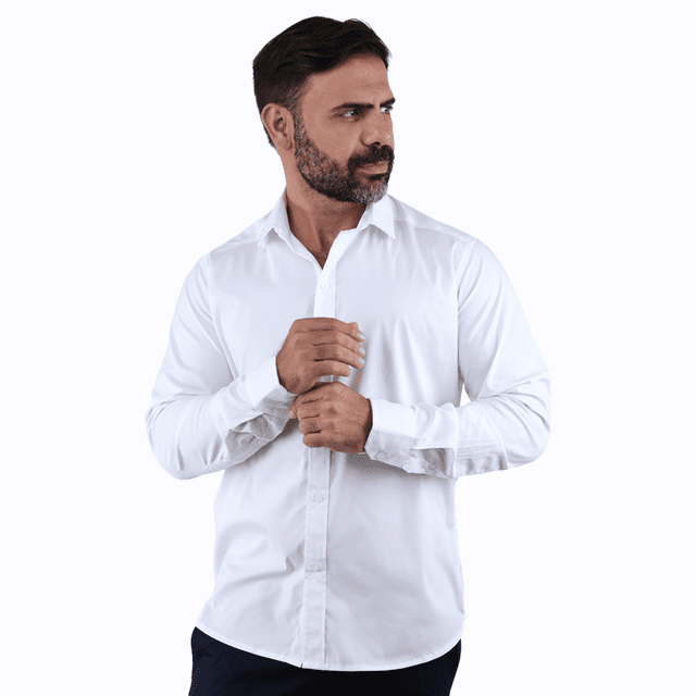 camisa de vestir manga larga blanco slim fit cuello italiano para hombre Camisa blanca slim fit con cuello italiano y botones frontales, vista frontal 3/4; modelo abotonando el puño derecho, tejido liso y corte entallado visible, fondo neutro. Ideal para looks formales o casuales, también suele usarse como capa ligera bajo saco.